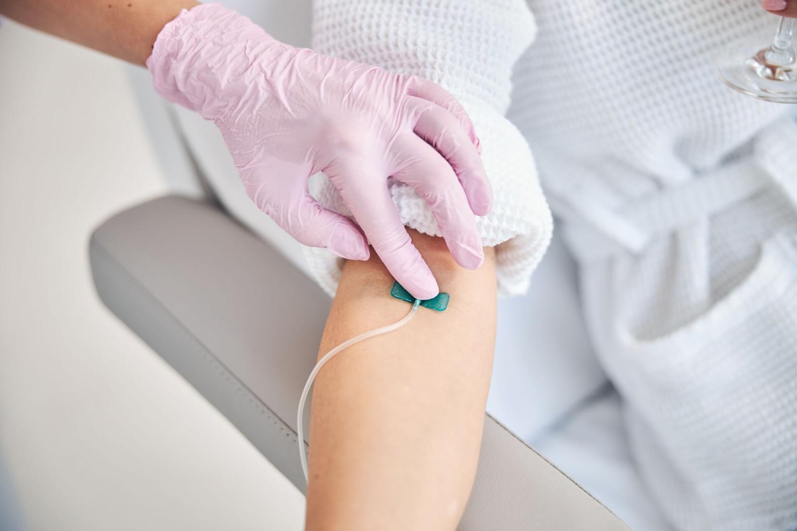 A close-up shot of a woman's arm being sanitized and prepared for IV Vitamin Infusion Therapy.