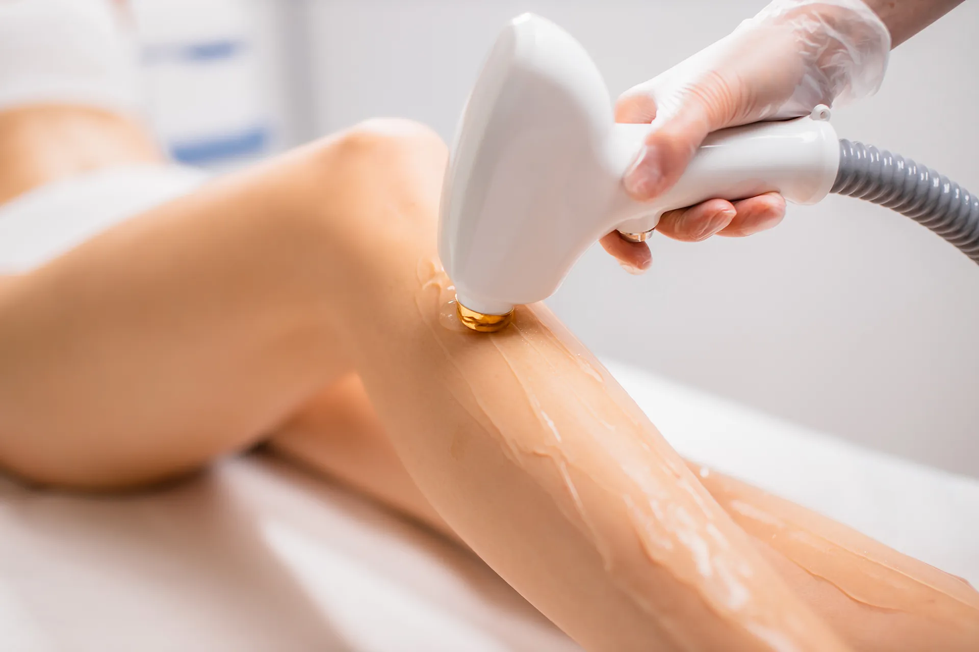 Close-up of a laser hair removal treatment on a woman's leg.